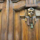 Foto 10. Il portone � a due ante, in legno, vetro e ferro battuto: hanno specchiature rettangolari in cui si inseriscono due sfingi scolpite ciascuna con un batacchio in ottone [foto di Gennaro Gargiulo]